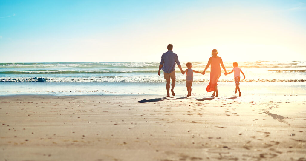 Rear view shot of a family enjoying some quality time together at the beach